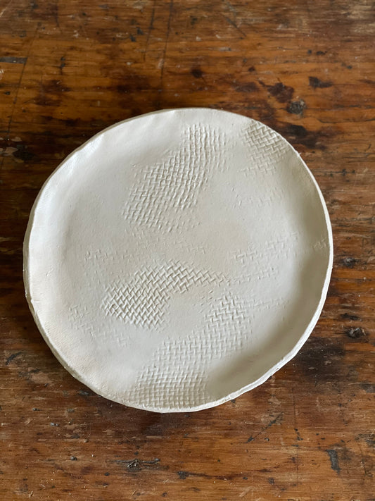 Handmade pottery white matte dessert plate with burlap texture.