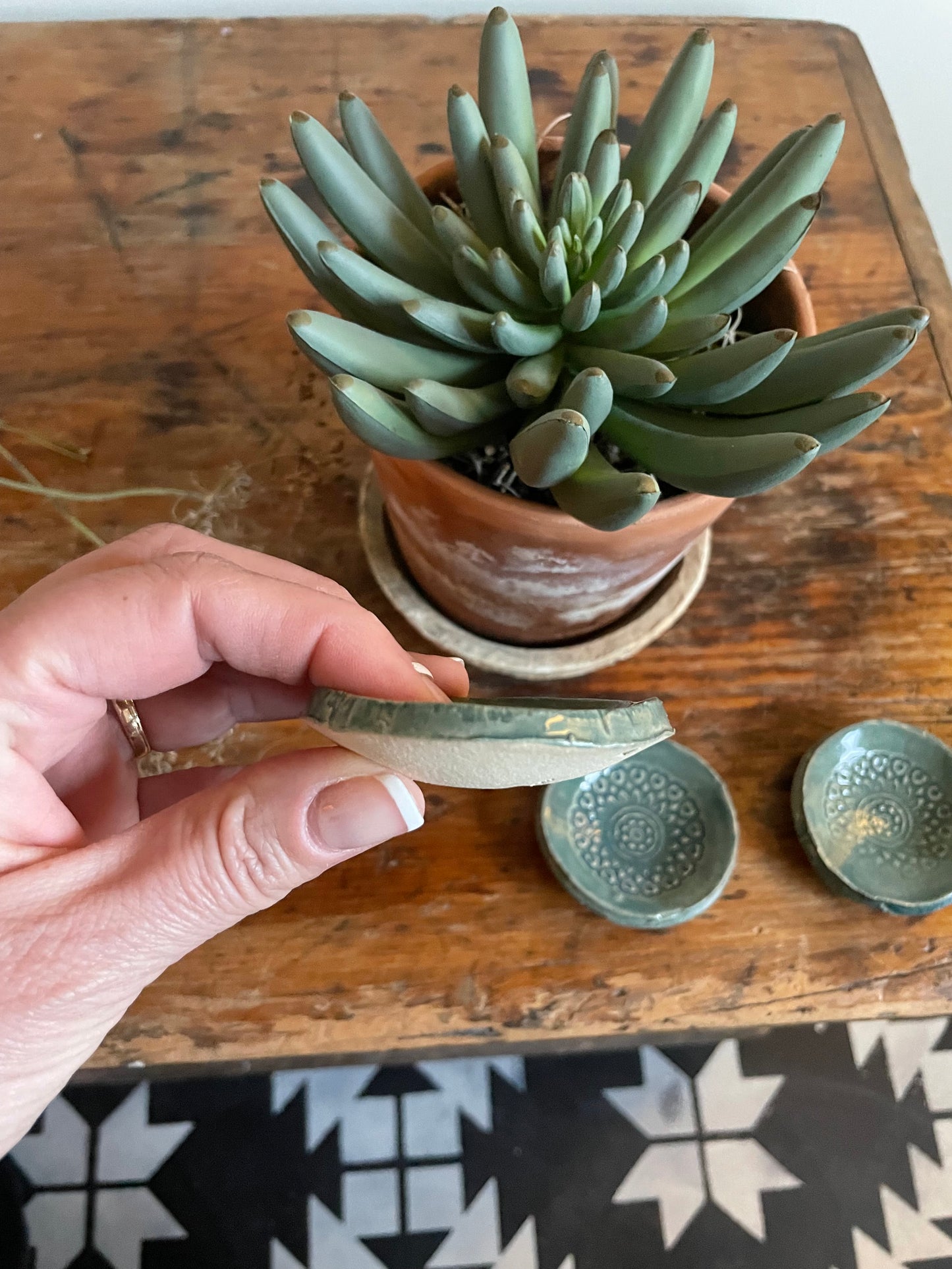 Showing the side of one of three tiny trinket dishes featuring the thickness.