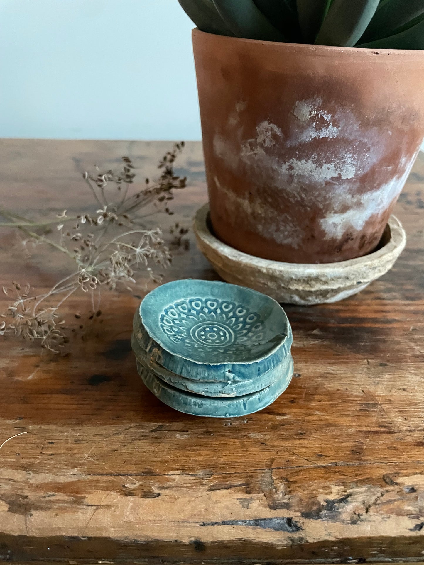 Stack of three tiny round dishes in green with a boho texture.