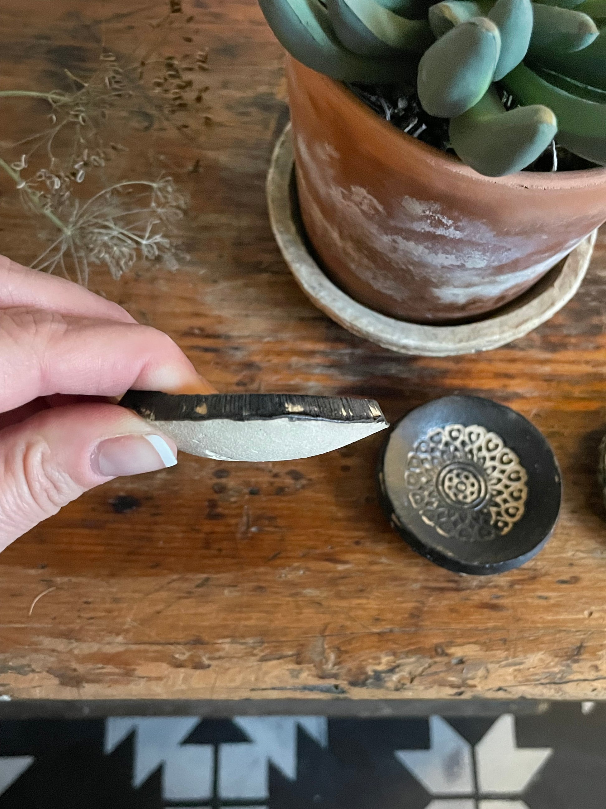 Side of tiny black trinket dish.